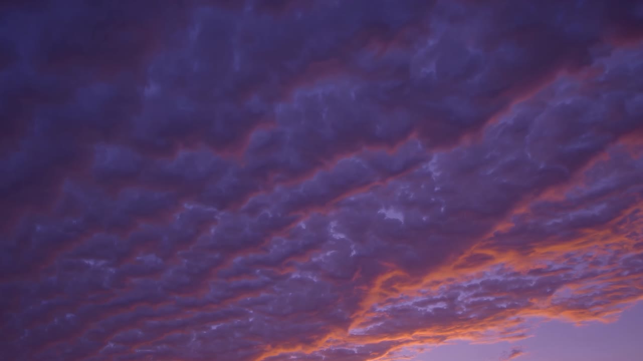 A dramatic video scene of a sunset sky, captured from a low angle