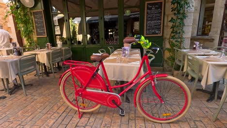 charming european street cafe with outdoor seating and red bicycle