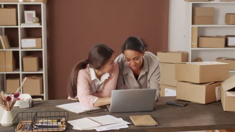 woman and woman sitting on the table talking about shipments