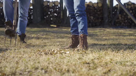 Vista-Cercana-De-Un-Rastrillo-Y-Pies-De-Mujer.-La-Mujer-Está-Quitando-Malas-Hierbas-En-El-Campo