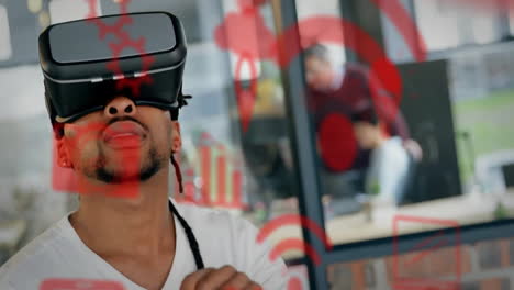 Animation-Mehrerer-Computeranwendungssymbole-über-Einem-Mann-Mit-Gemischter-Abstammung,-Der-Beim-Verwenden-Eines-VR-Headsets-Gestikuliert