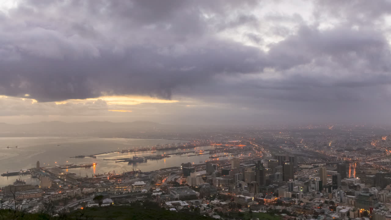 A static Time Lapse shot of sunrise over the City of Cape Town and the Waterfront Harbor, with changing light and dramatic cloud movement.