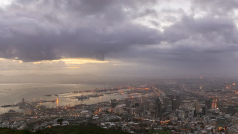 a static time lapse shot of sunrise over the city of cape town and the waterfront harbor, with changing light and dramatic cloud movement.