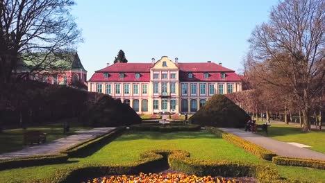 Drone-flying-up-and-forward,-then-look-down-on-the-palace-in-the-park