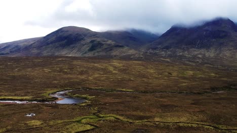 panning drone shot of scottish river valley mountain landscape