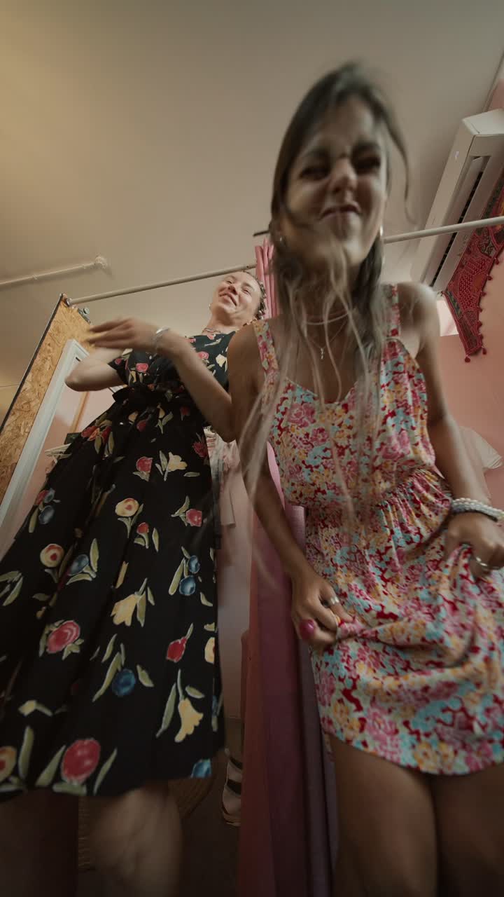 Two women in floral dresses posing in a store