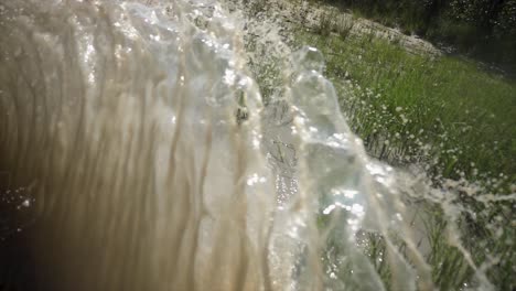 Ein-Auto-In-Zeitlupe-Fährt-Durch-Eine-Schlammpfütze,-Aus-Der-Schmutziges-Wasser-Spritzt