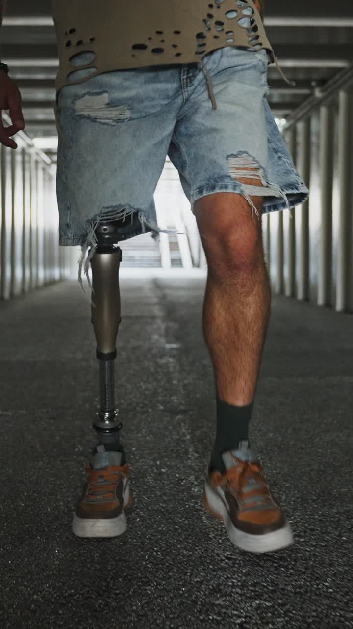 Man with prosthetic leg walking through a tunnel