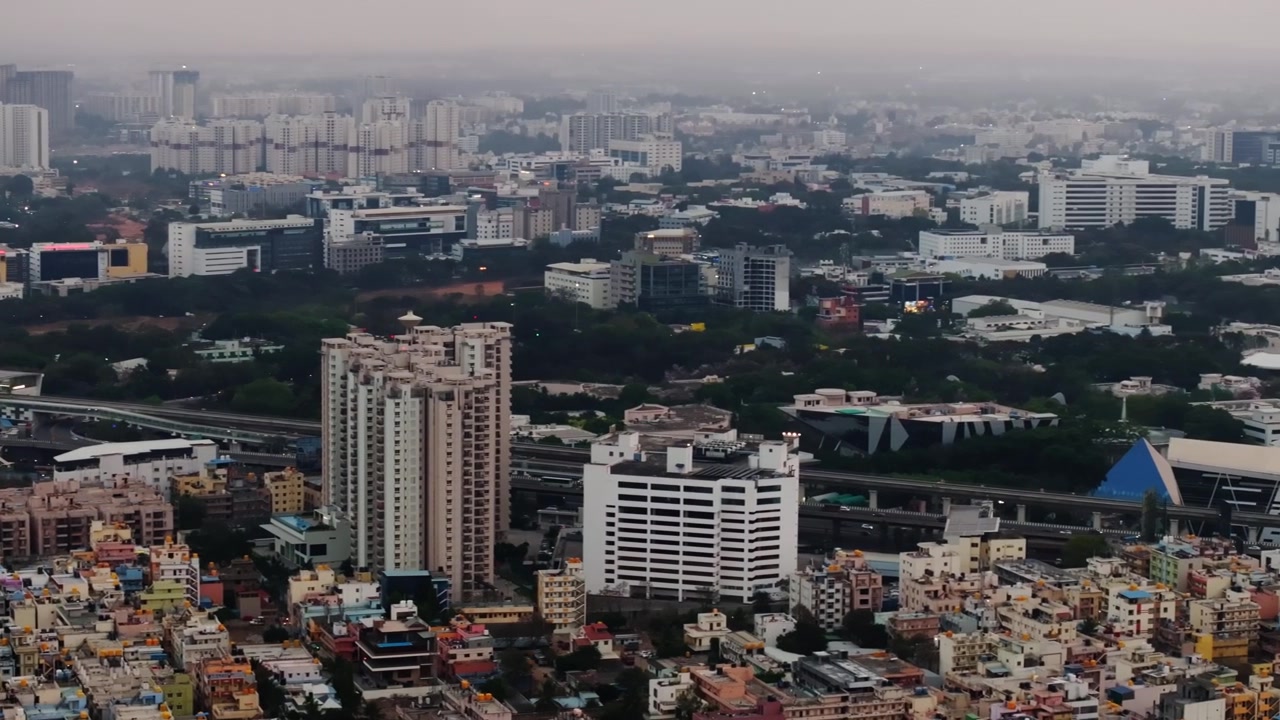 Linea della metropolitana con grattacieli, edifici residenziali, uffici aziendali e foschia a Electronic City, Bangalore, Karnataka, India. Di giorno, ripresa panoramica, ripresa con drone, 4K.