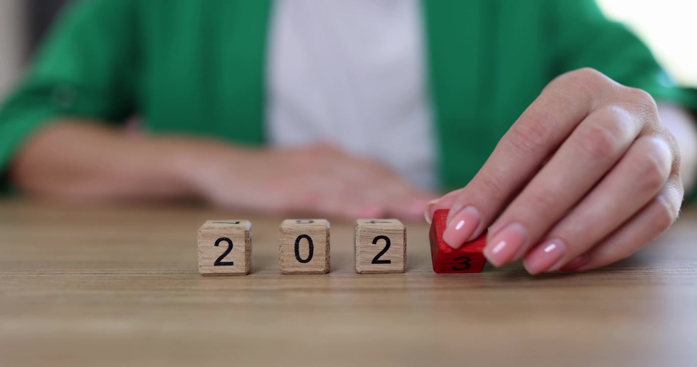 The hand changes year on cubes from 2022 to 2023 closeup