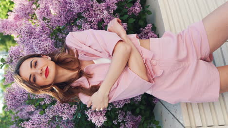 woman in pink outfit among lilacs