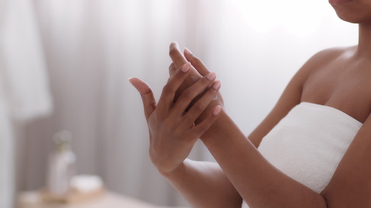 Kvinde smører lotion på sine hænder