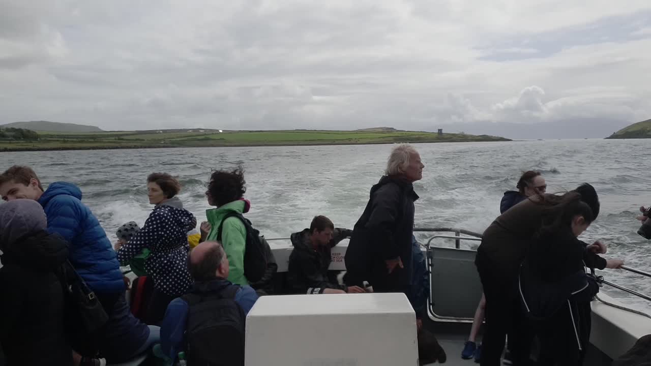People, some movement on a small boat travelling out of the harbour in Ireland.