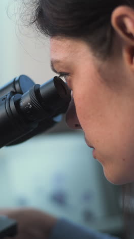 científico usando un microscopio y una computadora