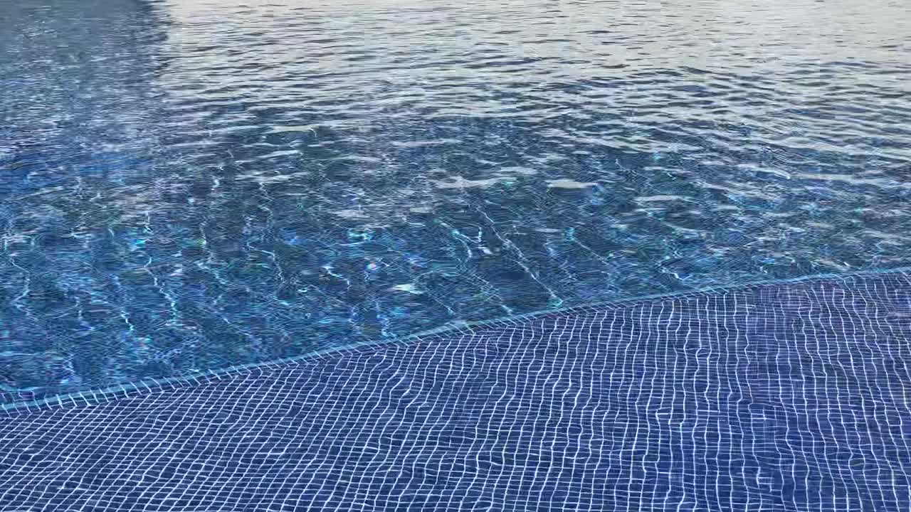 Et afslappende billede af vand, der bevæger sig over en mosaikblå flisebaggrund