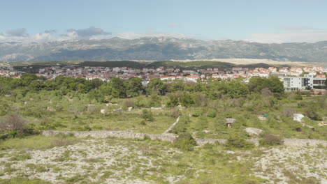 AERIAL:-Flight-over-wilderness,-land-in-Novalja,-Croatia-Nature-with-blue-sky-and-sun