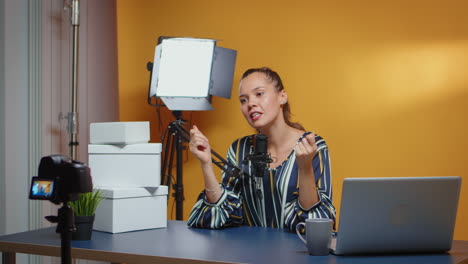 influencer hablando con la cámara y las cajas de regalos están en el escritorio