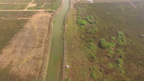 Drohnenaufnahme-Eines-Rückwärtsfluges,-Der-Einem-Flusslauf-Folgt-Und-Zum-Fernen-Horizont-Aufblickt