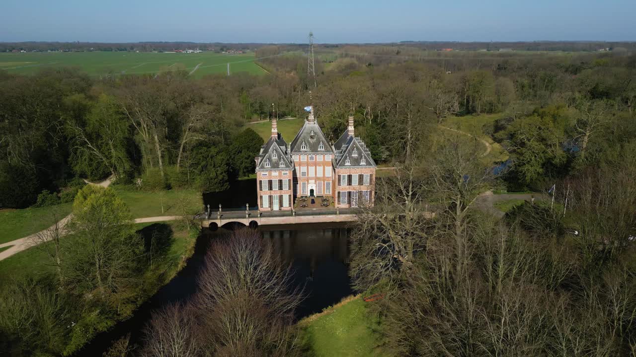 Scenic drone footage of Castle Duivenvoorde surrounded by water, trees and historic gardens in Voorschoten, South Holland