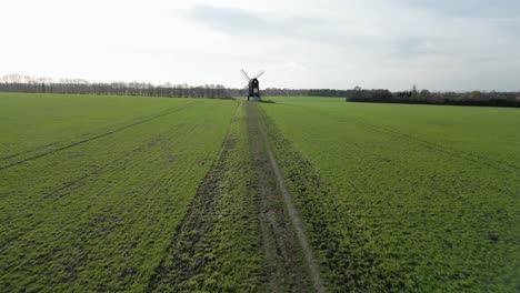 Aerial-view-following-agricultural-field-trail-towards-Pitstone-windmill-rural-Buckinghamshire-National-trust-landmark