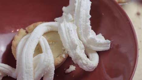 squirting whipped cream topping over sweet mince pie