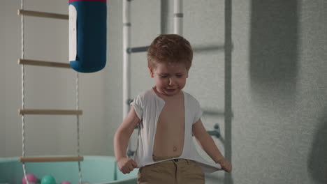 niño llora camiseta blanca jugando héroe de película de acción