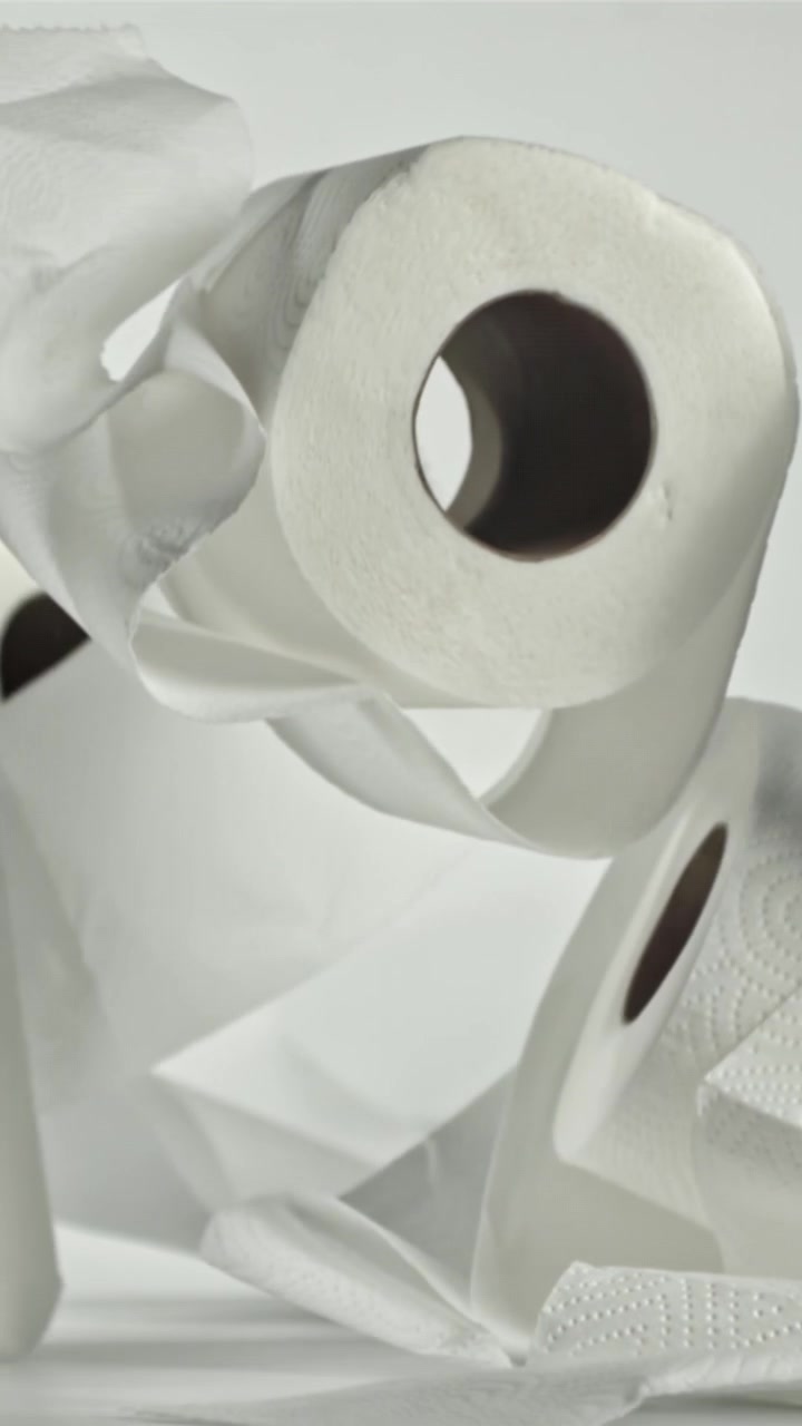 White Toilet Paper Rolls Falling in Slow Motion on a Clean Surface