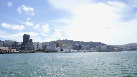 una foto soleada de la ciudad de wellington desde el otro lado del mar
