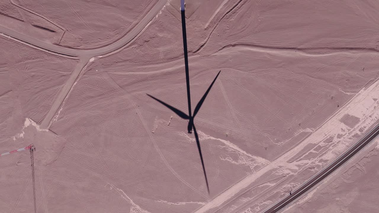 Aerial view around wind turbines with a dramatic sky at a desert in Chile