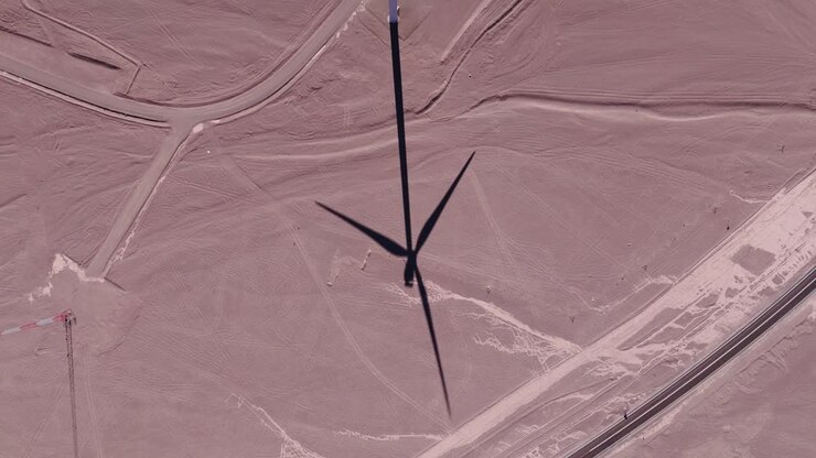 Aerial view around wind turbines with a dramatic sky at a desert in Chile