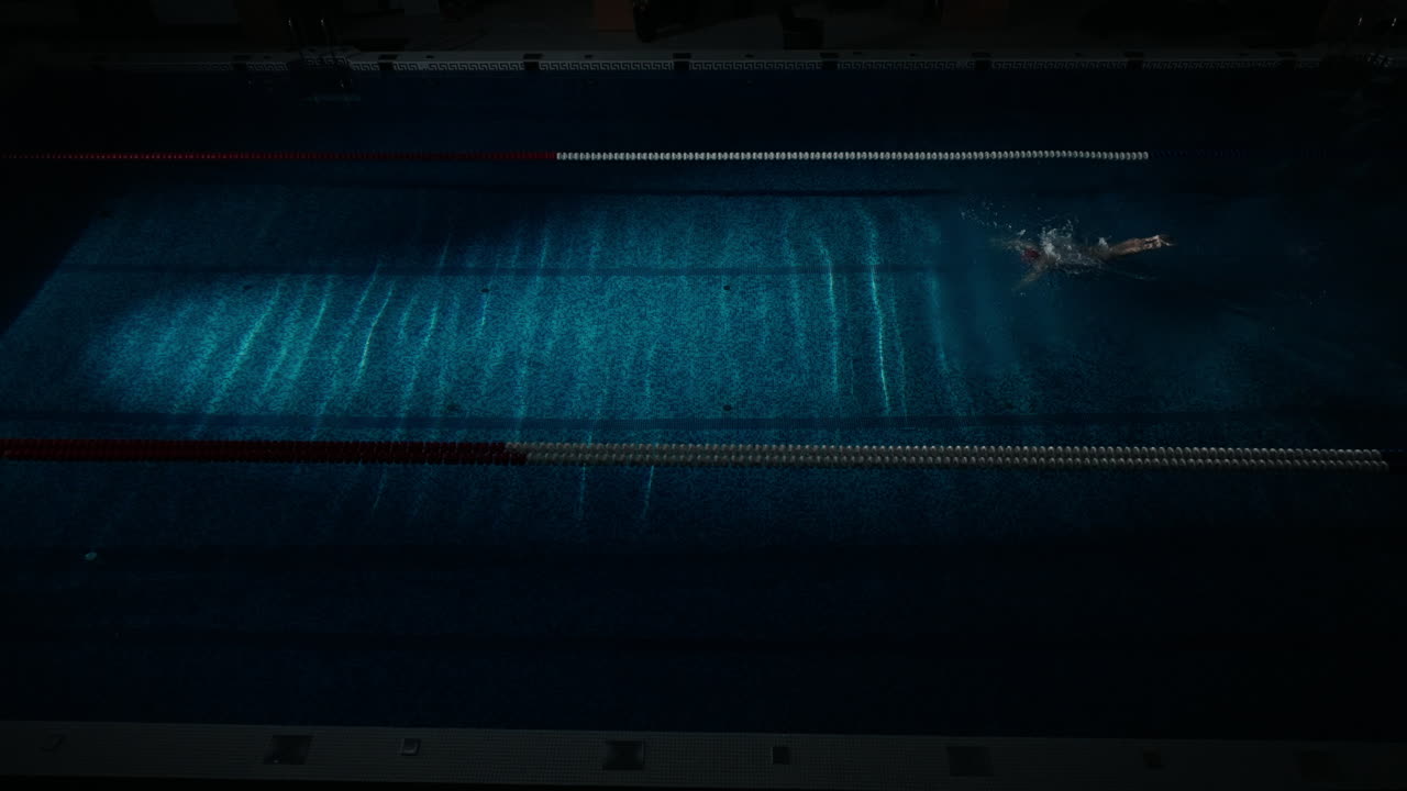 A swimmer in a swimming pool at night