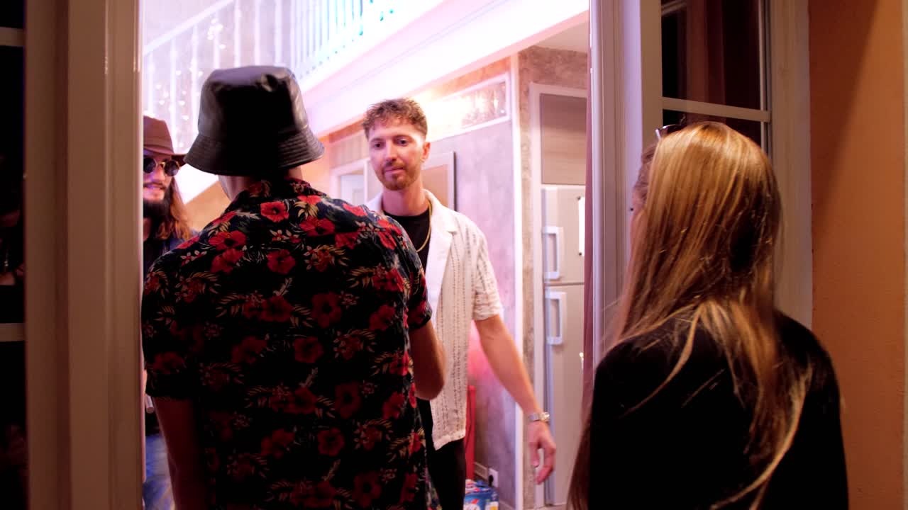 close-up shot of people arriving at a house party and entering