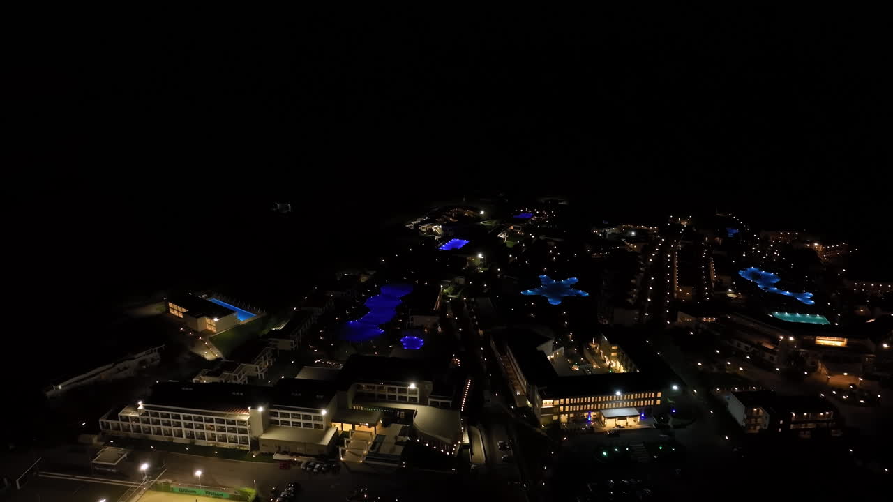 Panoramic drone shot of many all-inclusive resorts, night on the Greek coastline