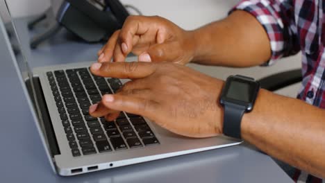 Senior-male-executive-using-laptop-at-desk-4k