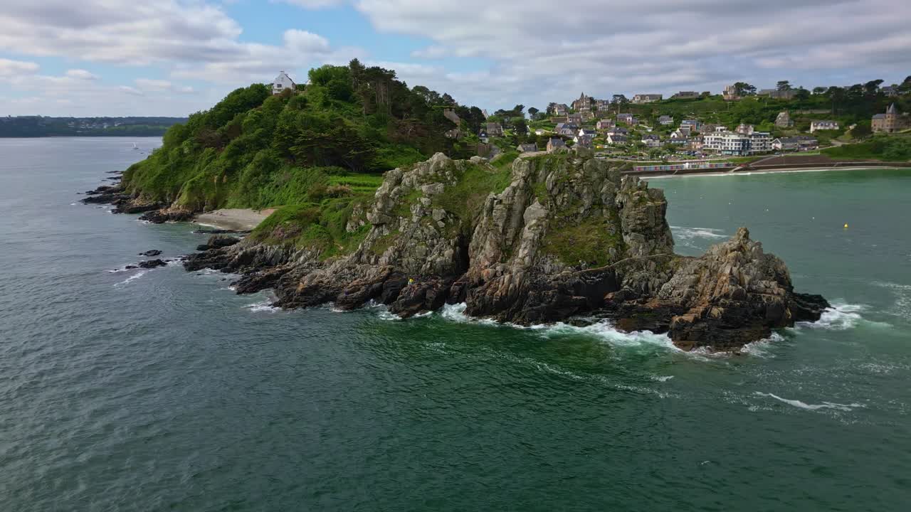 Panoramic drone movement around the Pointe du Chateau rocky coastal endpoint with Trestrignel beach, Perros-Guirec, Brittany, France.