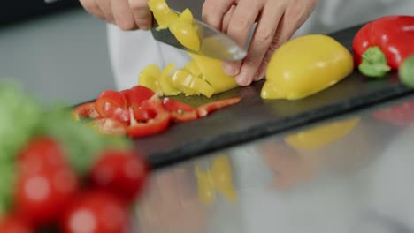 chef masculino cocinando comida fresca en un restaurante de cocina. manos de primer plano cortando pimienta