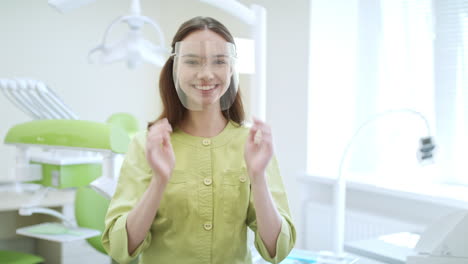 female dentist wearing safety glasses. happy medical student in dental clinic