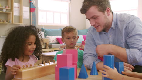 teacher and pupils using wooden shapes in montessori school