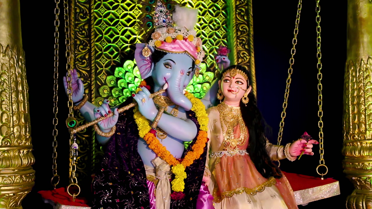 Beautiful Lord Ganesha idol in Radha-Krishna style on decorated swing, perfect for Ganesh Chaturthi and Indian festival videos.