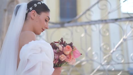 bride holds beautiful wedding bouquet before her face bride holds beautiful wedding bouquet before her face wedding day of bride in bridal gown