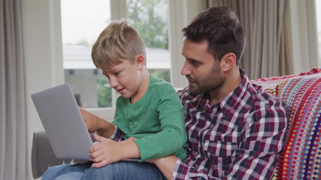 padre e hijo usando una computadora portátil en un hogar cómodo 4k