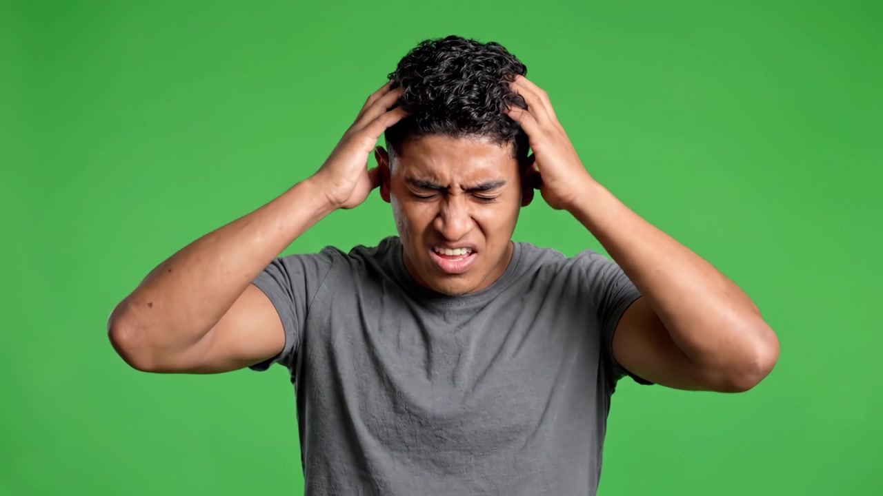 A Young Man Conveying Distinct Emotions Against a Green Screen Background, Transitioning from a Surprised Expression to a Somber Reflection in Two Frames