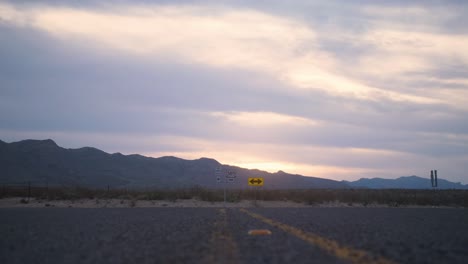 Puesta-De-Sol-En-La-Montaña-Del-Oeste-De-Texas-Con-Deslizamiento-De-ángulo-Bajo-A-Través-De-La-Autopista-4k