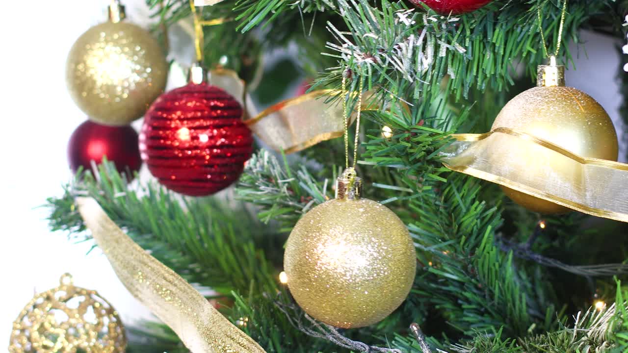 árbol de navidad brillante con luces parpadeantes y poniendo ornamento de brillo dorado