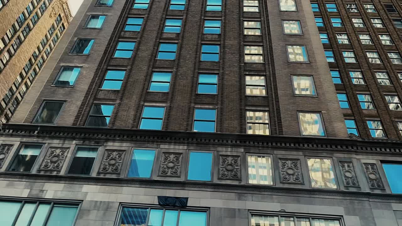 Time lapse driving past the many high rise buildings in the city center of Manhattan with buildings reflecting in the windows