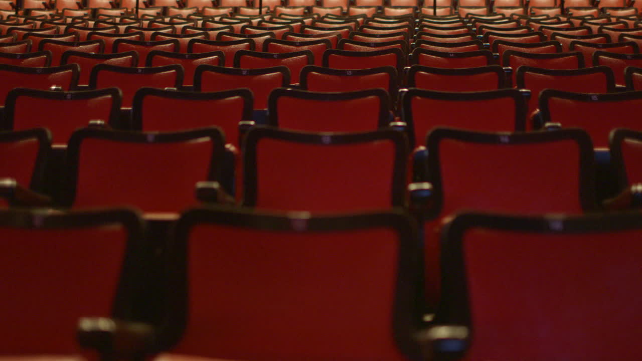 slow drift over empty red theater seats