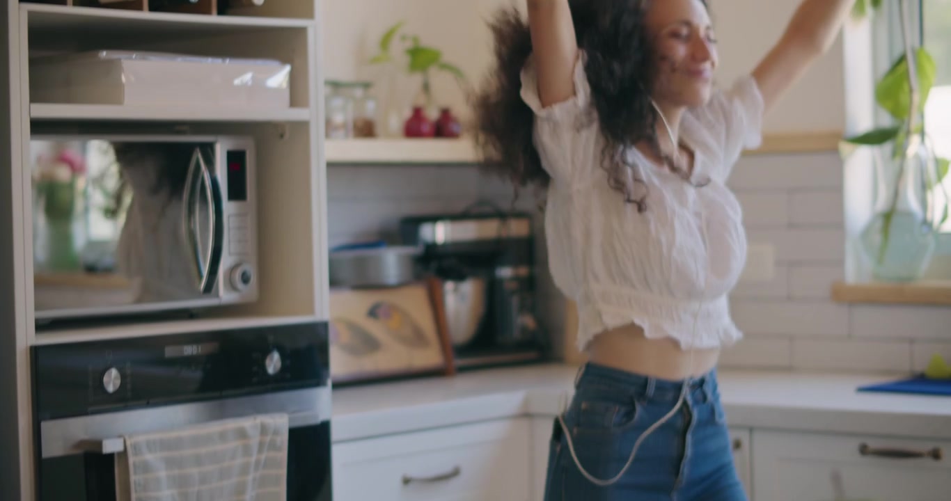 Donna che balla nella cucina luminosa