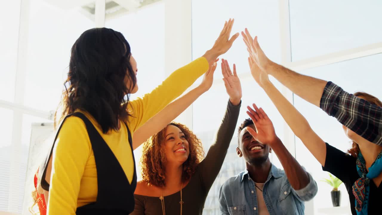 Group of happy executives giving high five to each other