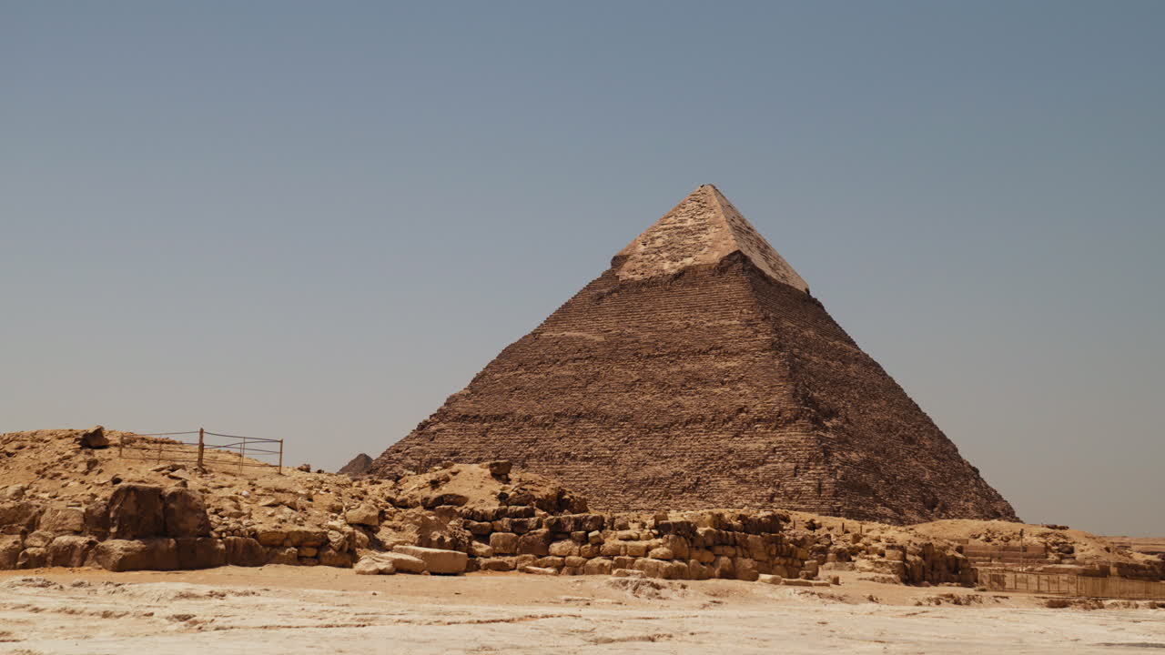 Wide view of the Great Pyramid of Giza in Egypt, showing ancient stone blocks, desert landscape, and clear sky, symbolizing early civilization, history, and architectural achievement