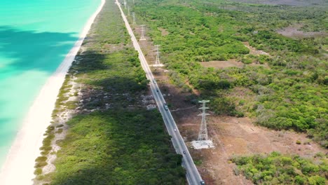 Toma-Aérea-De-Un-Auto-Conduciendo-En-Una-Carretera-Por-El-Golfo-De-México-Durante-El-Día-Soleado